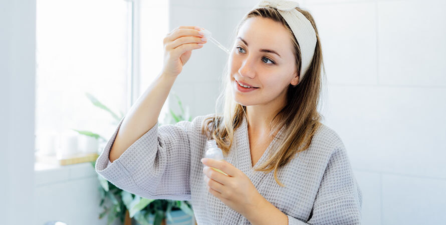 Woman checking her skincare routine in the bathroom mirror